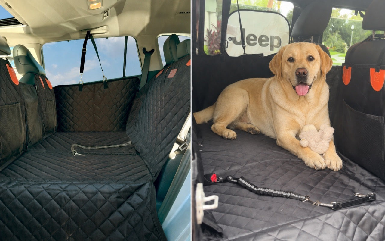 A Labrador lying settled across the back seat of a Jeep on a flat quilted surface, with a toy under one paw.